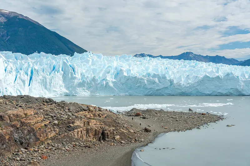 A group of trekkers wearing crampons walking on the surface of the Perito Moreno Glacier