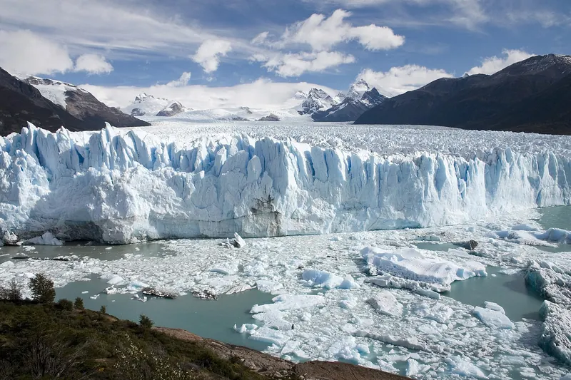 The blue ice face of the Perito Moreno Glacier meeting the turquoise water of Lago Argentino