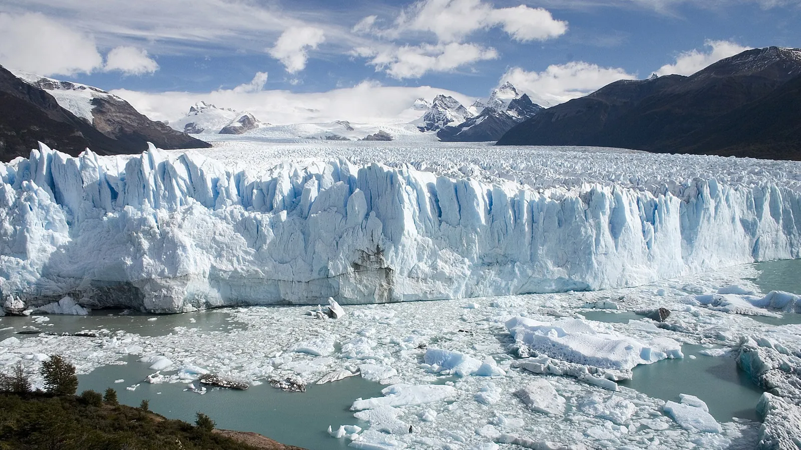 The blue ice face of the Perito Moreno Glacier meeting the turquoise water of Lago Argentino