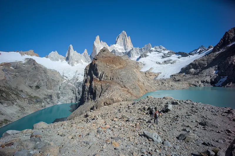 The granite spires of Mount Fitz Roy rising above forests and a valley in Patagonia