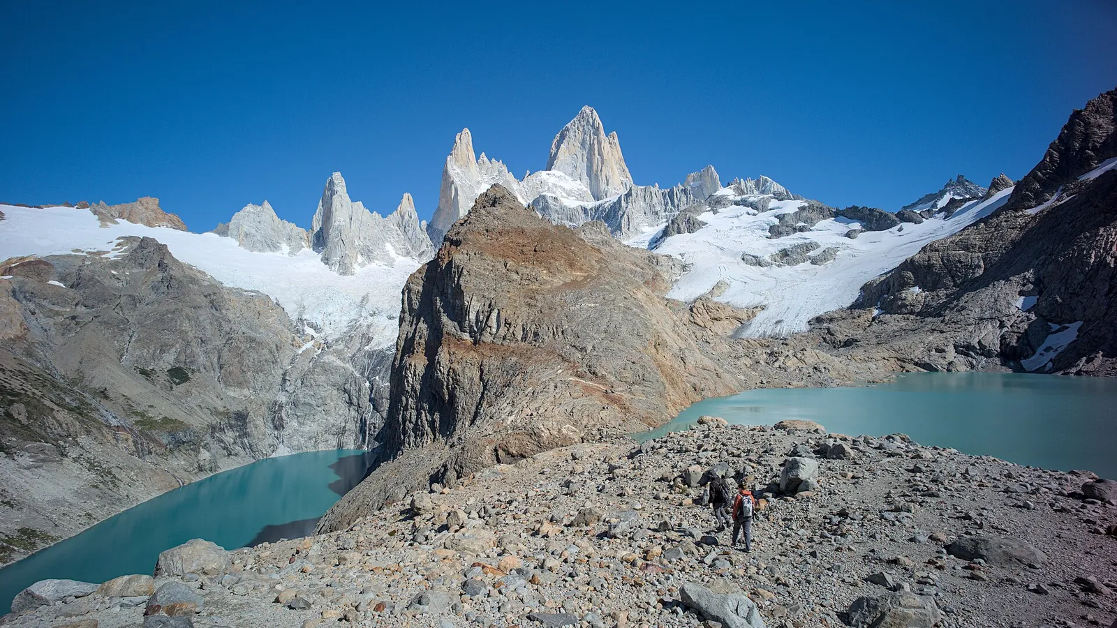 The granite spires of Mount Fitz Roy rising above forests and a valley in Patagonia