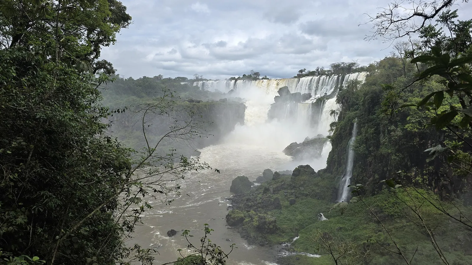 Many cascades of Iguazú Falls seen from the Argentine side, surrounded by rainforest