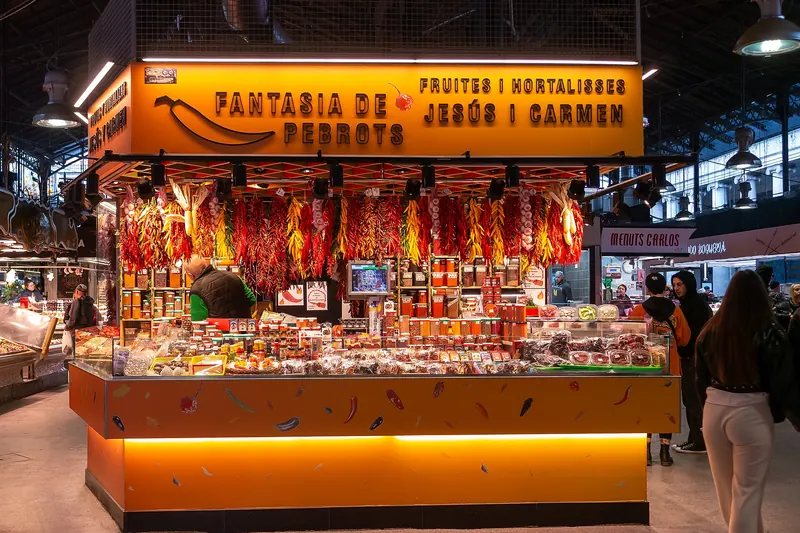 Fruit and vegetable stalls under the ironwork roof of the Boqueria market in Barcelona