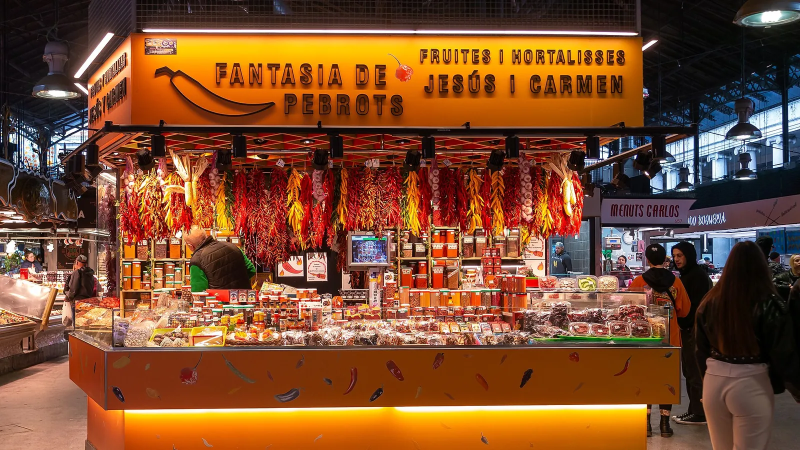 Fruit and vegetable stalls under the ironwork roof of the Boqueria market in Barcelona