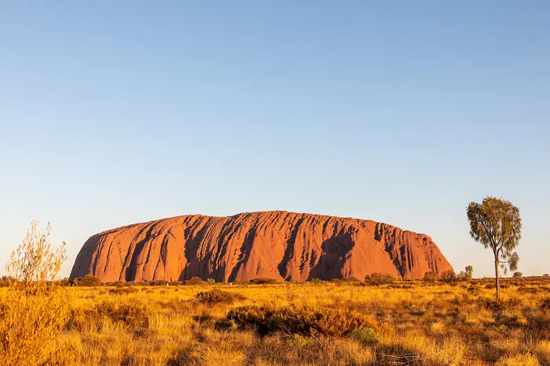 Uluru, the great red sandstone monolith, standing above the desert plain