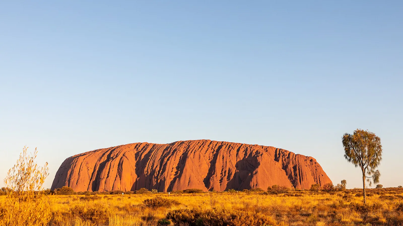 Uluru, the great red sandstone monolith, standing above the desert plain