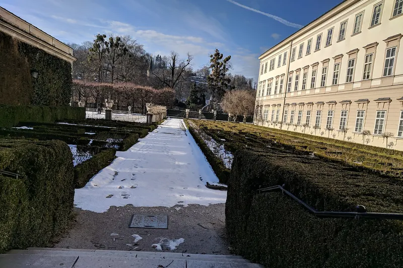 The formal gardens of Mirabell Palace in Salzburg, with the fortress visible behind