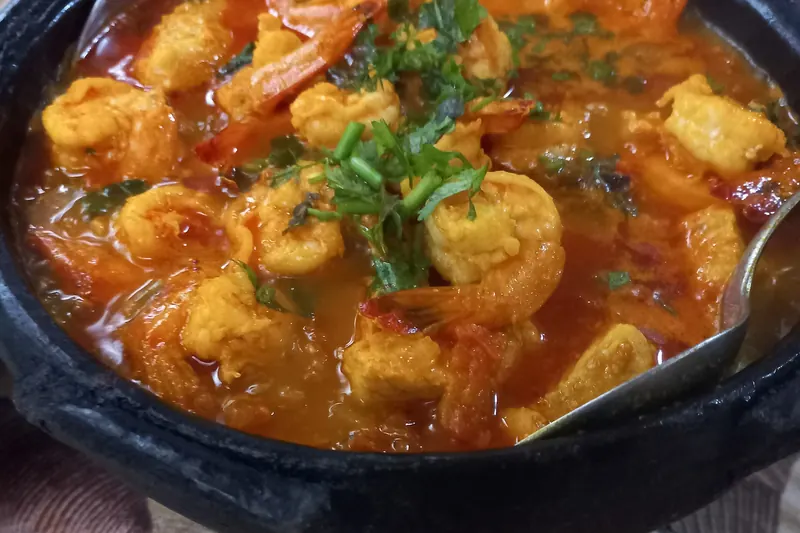 A clay pot of moqueca fish stew with coconut milk and peppers