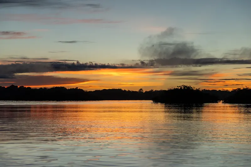 The sun setting over the Amazon rainforest and river