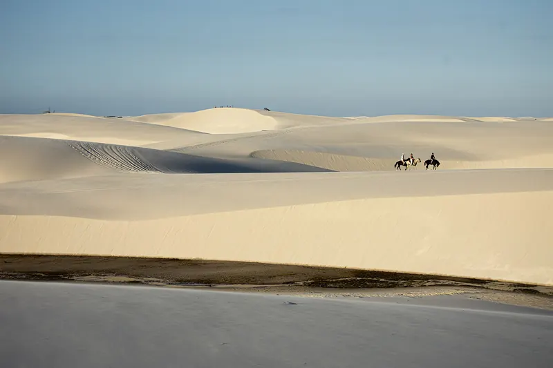 A blue lagoon among white sand dunes in Lençóis Maranhenses National Park