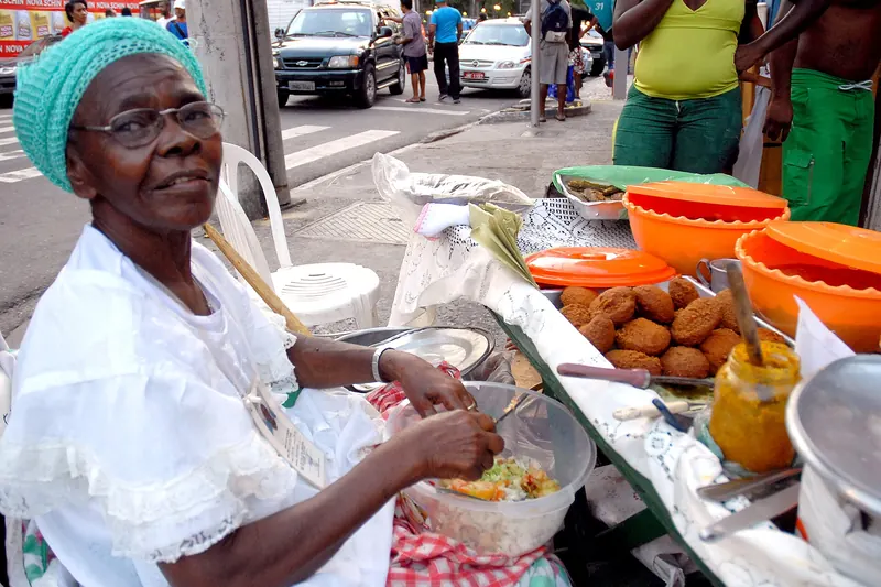 A baiana in traditional white dress selling acarajé in Salvador