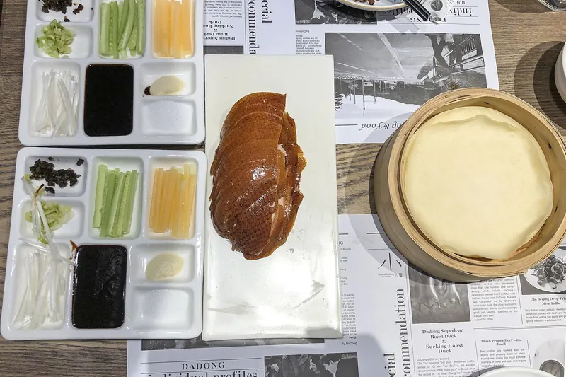 A whole roasted Peking duck with lacquered skin, ready to be carved