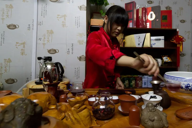 Tea being poured in a gongfu tea ceremony over small cups