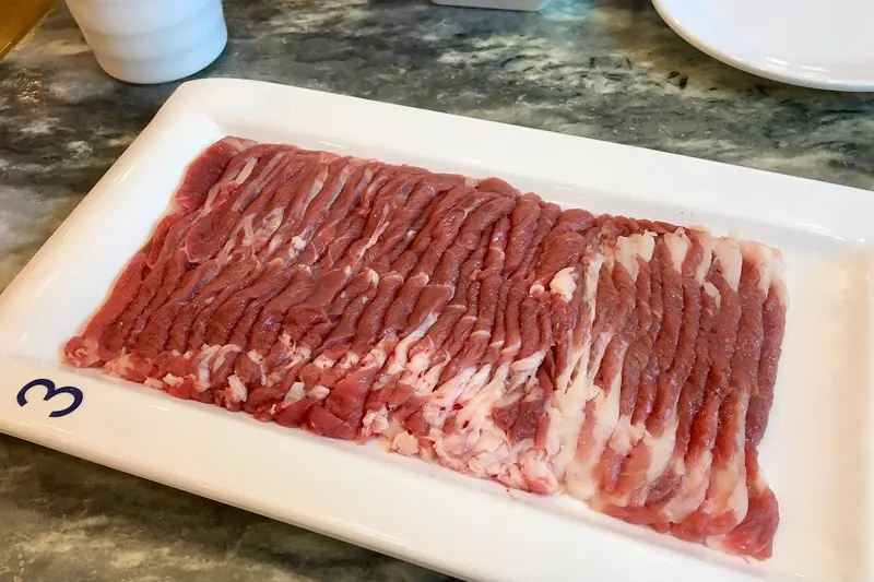 Paper-thin hand-cut lamb slices arranged for instant-boiled hotpot