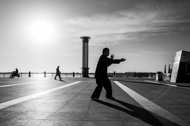 People practising tai chi in a Beijing park at dawn