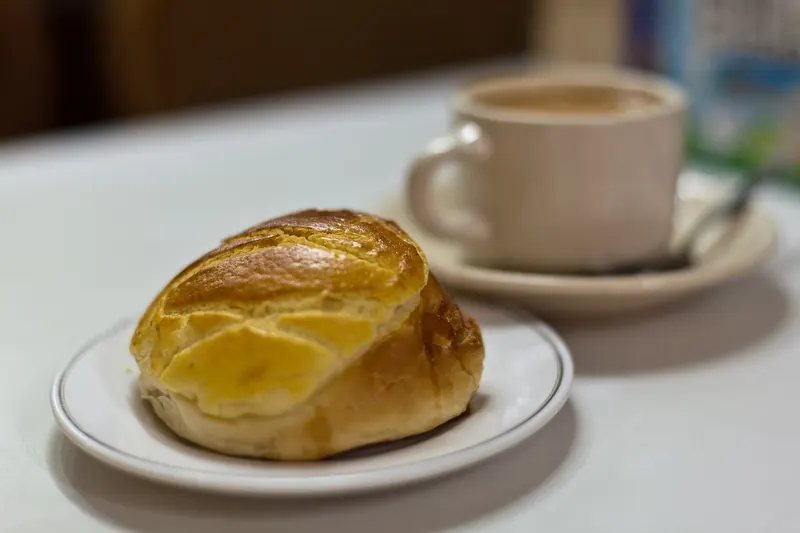 A pineapple bun served alongside Hong Kong-style milk tea