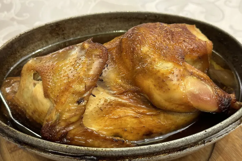 Beggar's chicken, its clay wrapping cracked open at the table