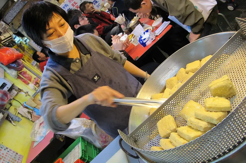 Fermented tofu frying in a street-side wok