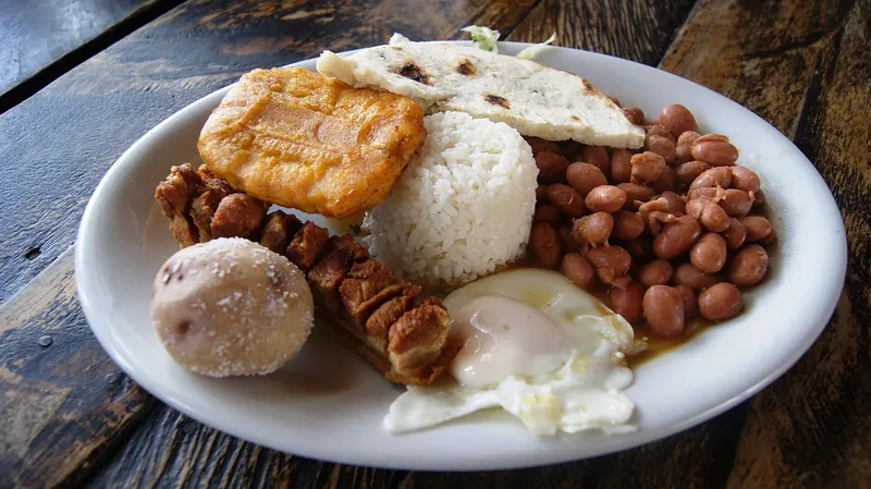 A large plate of bandeja paisa with beans, rice, meat, egg and plantain