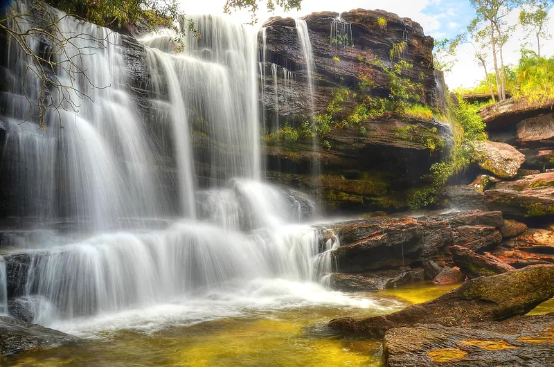 The Cascada los Cuarzos waterfall on the Caño Cristales river with coloured rocks