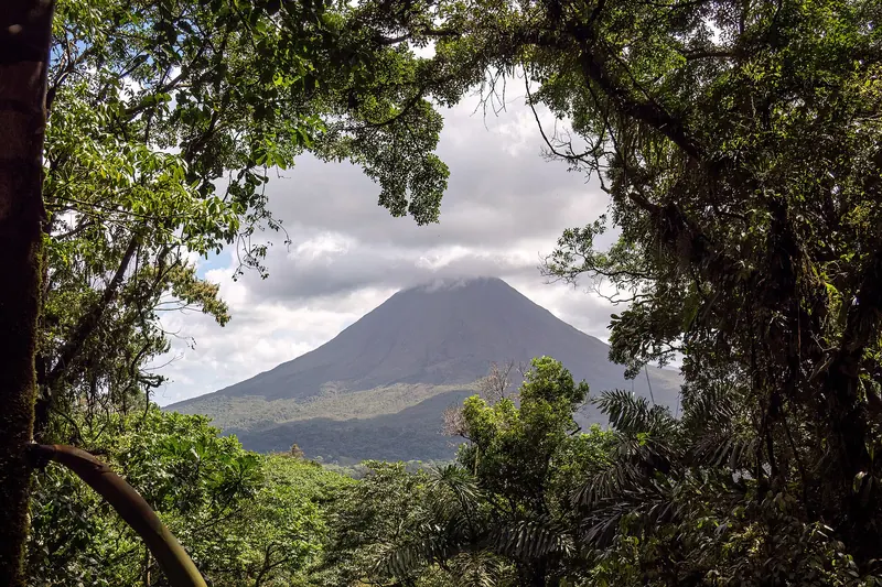 Arenal Volcano rising above green rainforest