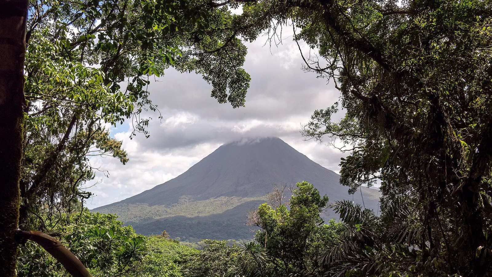 Arenal Volcano rising above green rainforest