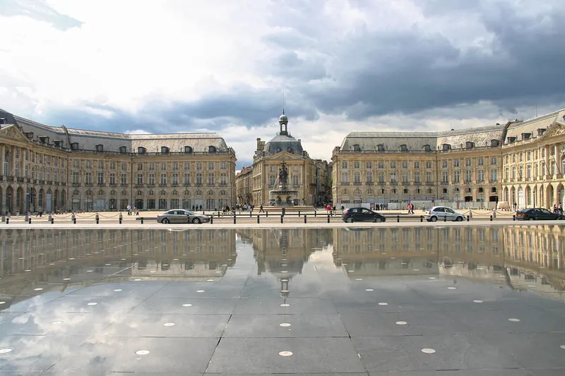 The 18th-century facade of the Place de la Bourse reflected in the Miroir d'Eau