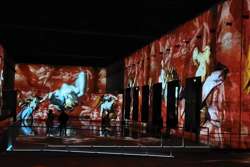 Digital art projections covering the concrete walls of the Bassins des Lumières submarine base