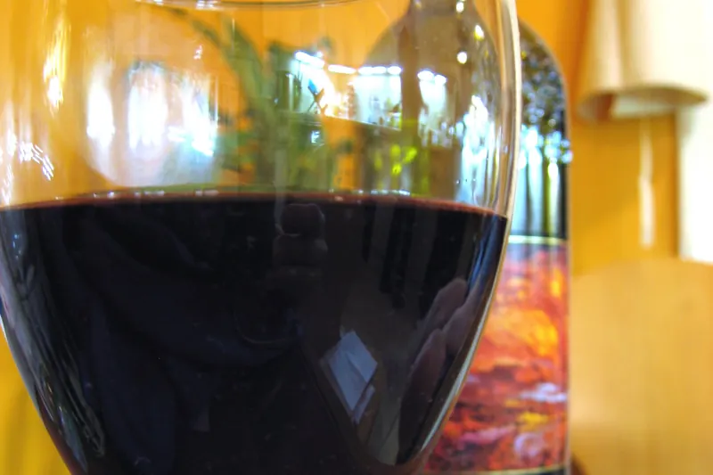 A bottle and glass of red Bordeaux blend