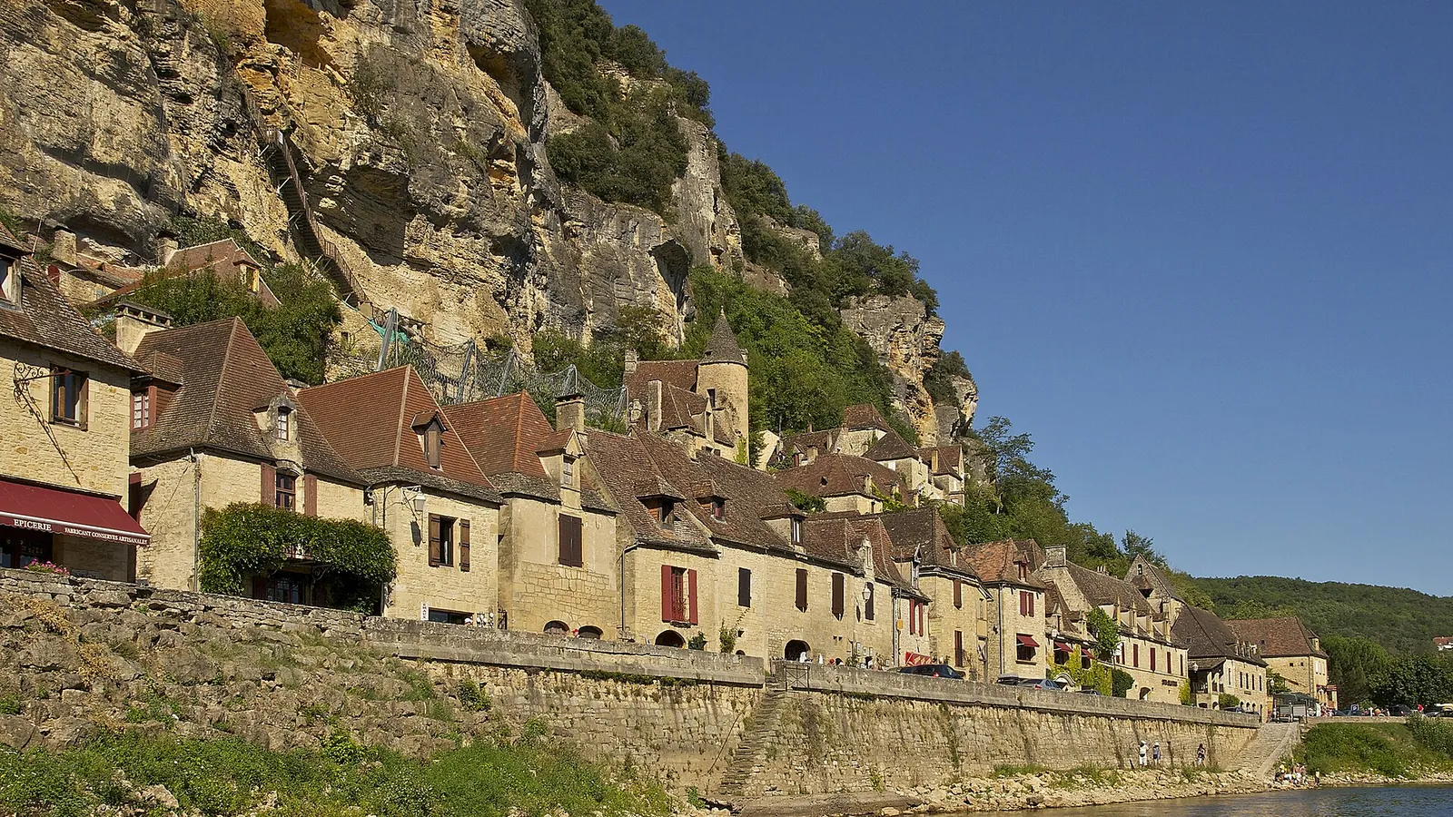 The village of La Roque-Gageac beneath a limestone cliff on the banks of the Dordogne river