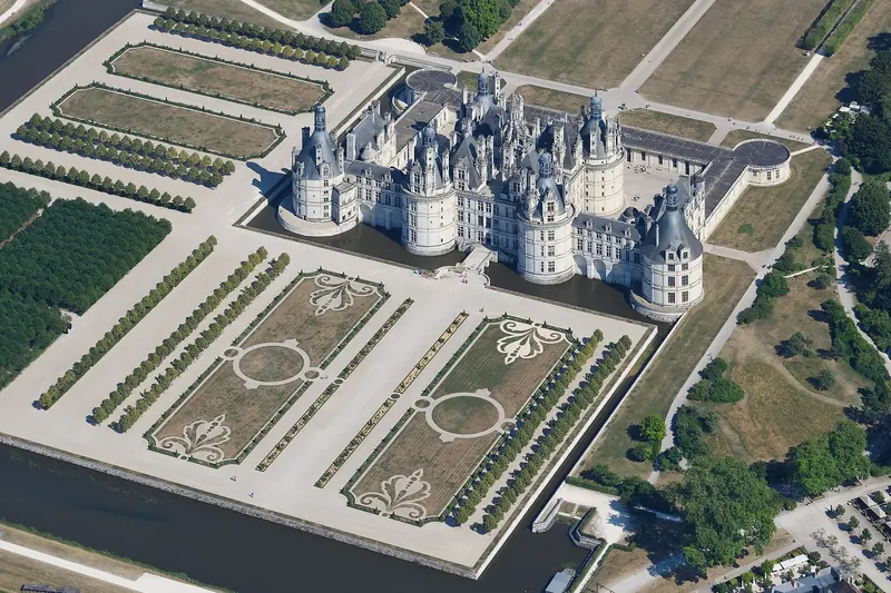 Aerial view of Château de Chambord's turreted roofline and formal gardens