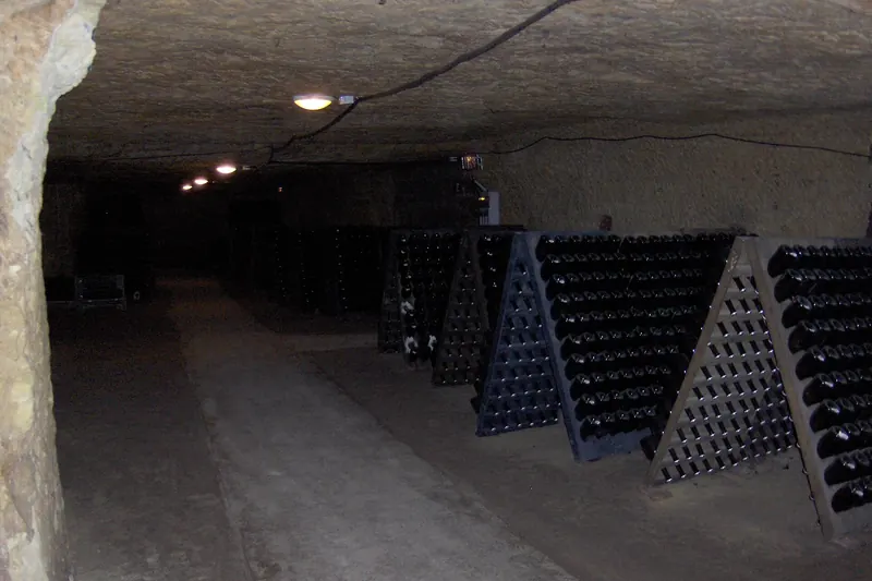 Sparkling wine bottles racked inside a tufa cave cellar at Vouvray
