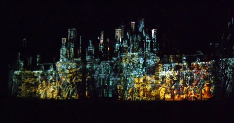 Coloured light projections on the facade of Château de Chambord after dark
