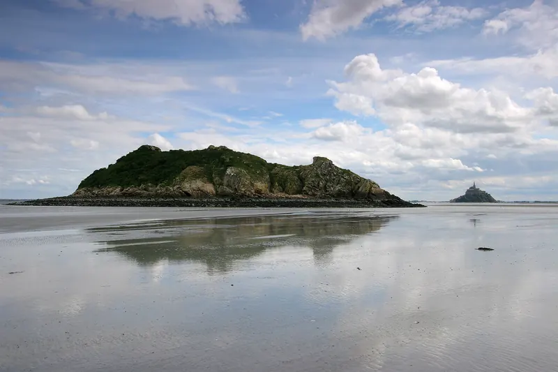 Mont-Saint-Michel and the island of Tombelaine seen from out on the bay's sand flats