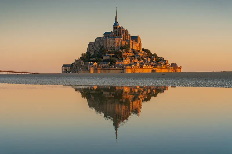 The abbey of Mont-Saint-Michel rising from the tidal flats at sunrise