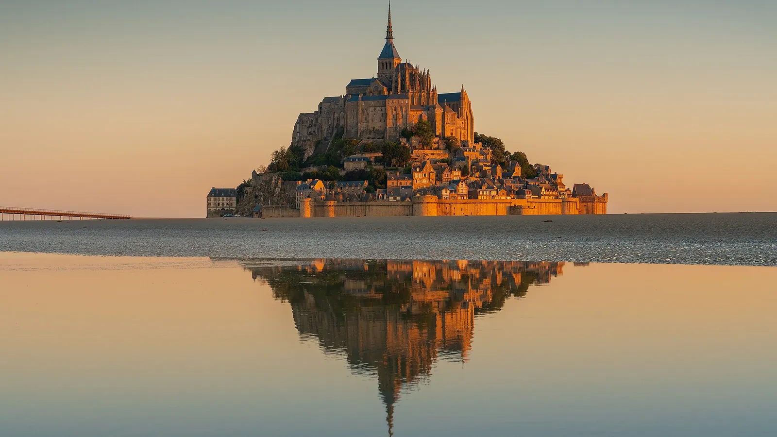 The abbey of Mont-Saint-Michel rising from the tidal flats at sunrise