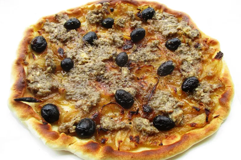 Pissaladière topped with slow-cooked onions, anchovies and black olives