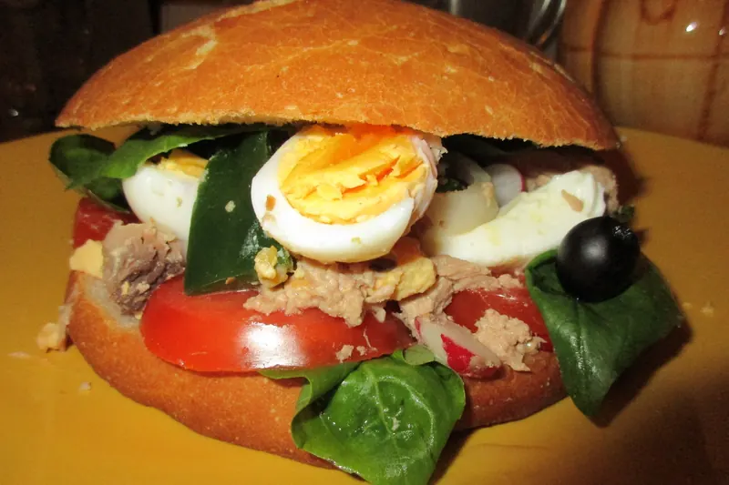 A pan bagnat — salade niçoise pressed into a round loaf