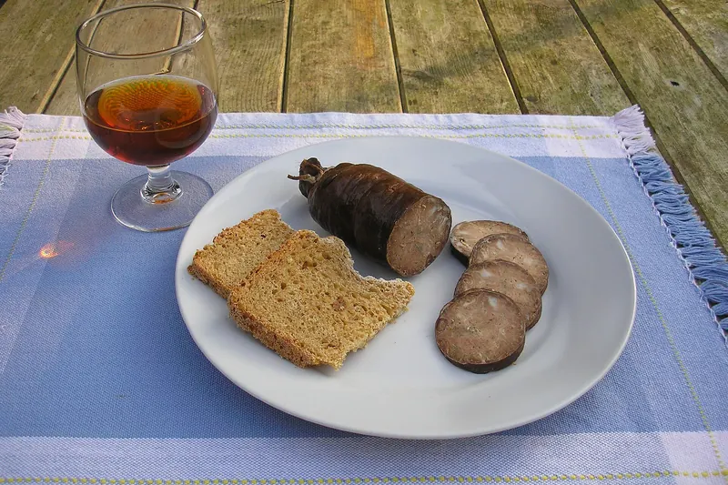 Sliced andouille de Vire served with a glass of pommeau