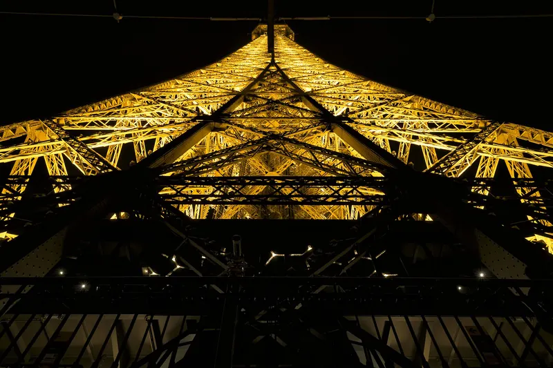 Looking up through the Eiffel Tower's iron lattice from the second floor