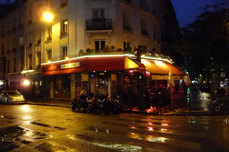 A corner bar lit up at night in Paris