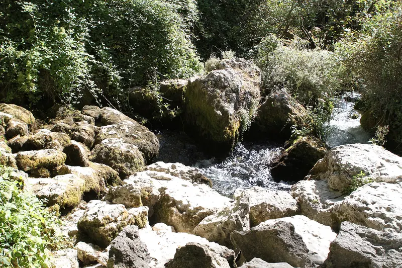 The clear water of the Sorgue running over rocks at Fontaine-de-Vaucluse