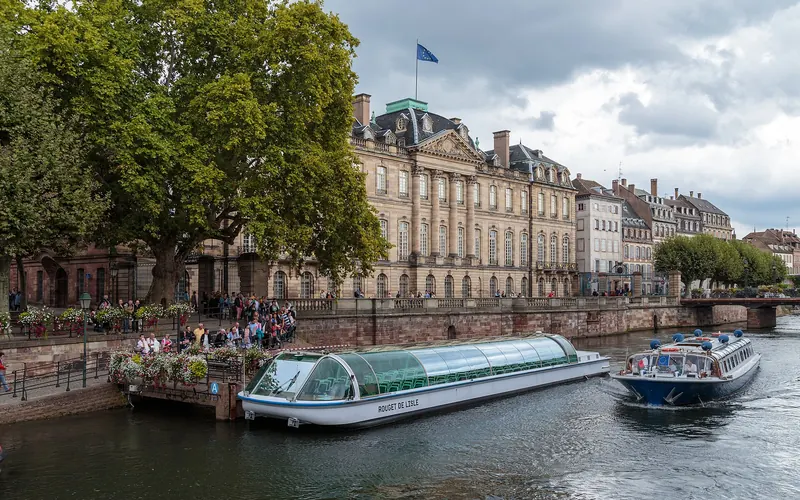 Covered tour boats on the Ill in front of the Palais Rohan