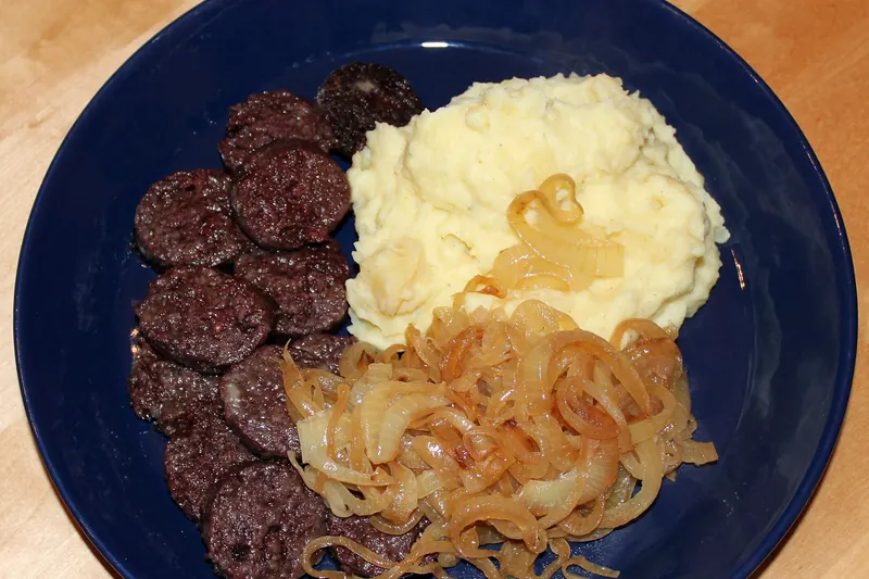 A plate of Himmel un Ääd, mashed potato and apple sauce with blood sausage