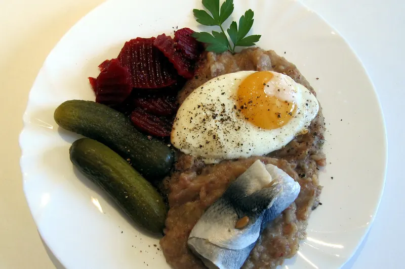A plate of Hamburg-style Labskaus with fried egg and herring