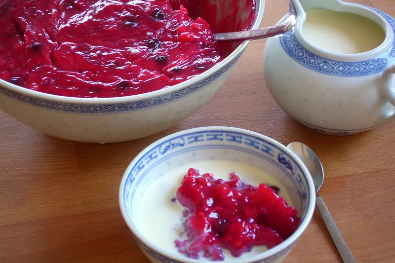 A bowl of Rote Grütze berry compote with vanilla sauce