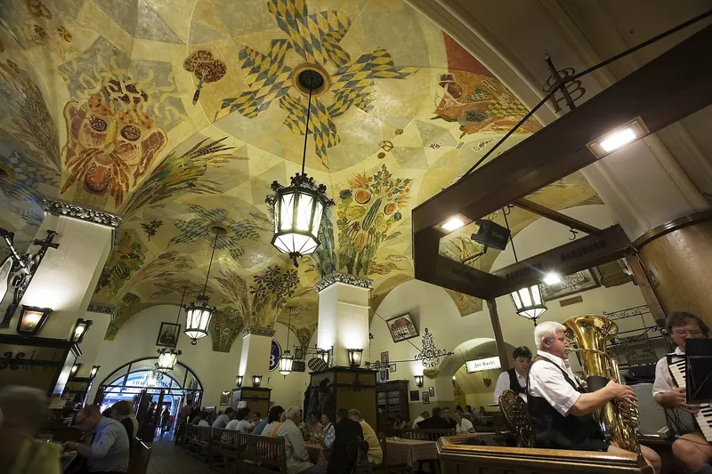 The painted vaulted ceiling and communal tables inside the Hofbräuhaus