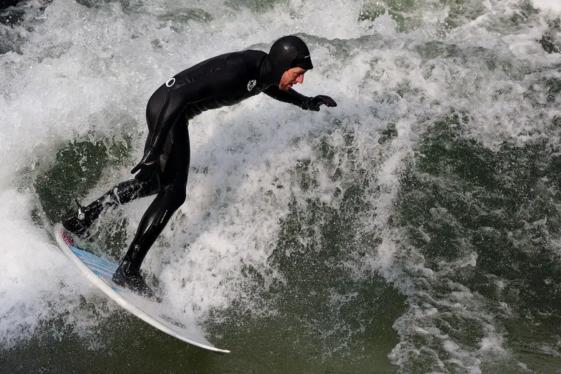 A surfer riding the standing wave on Munich's Eisbach stream