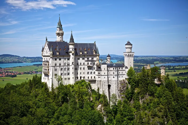 Neuschwanstein Castle rising from the forest above the Bavarian countryside