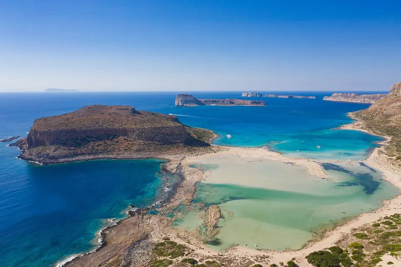 Aerial view of the turquoise water and pink-tinged sand of Balos Lagoon